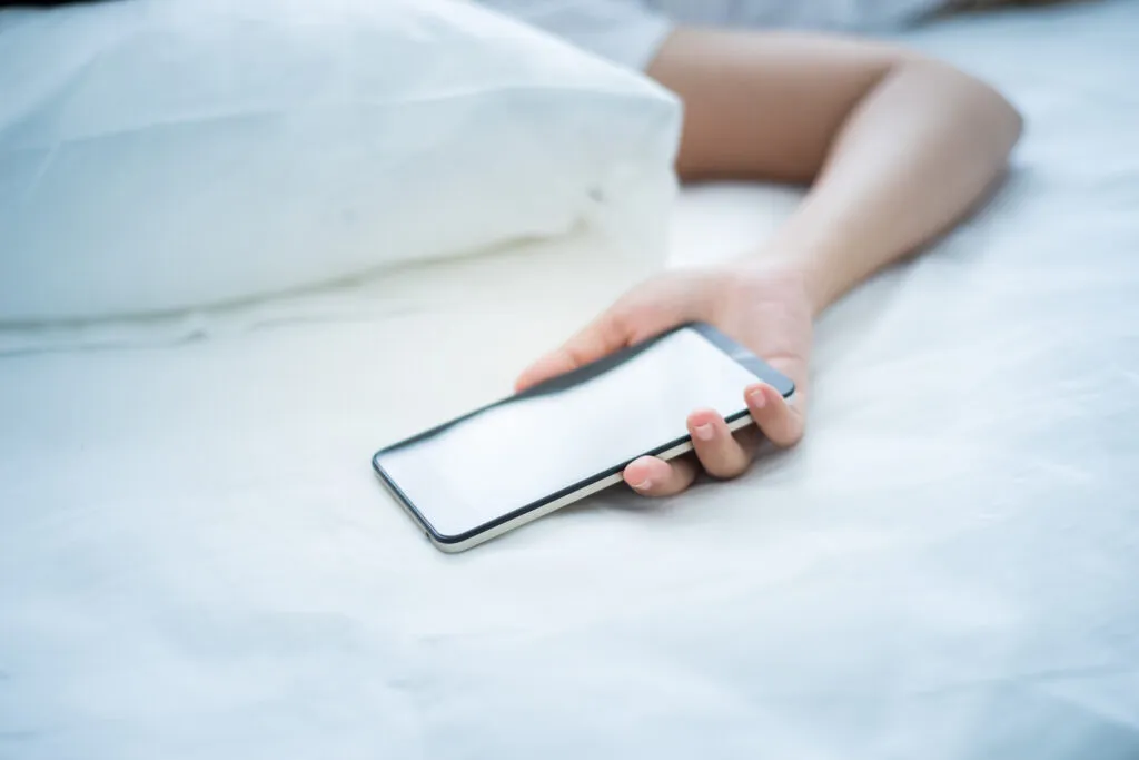 Seorang Wanita Tidur Memegang Smartphone